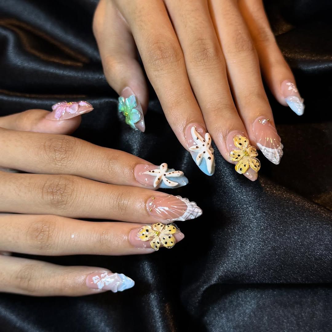 3D-zeesterren, schelpen en bloemen op lange nagels, op zwart satijn