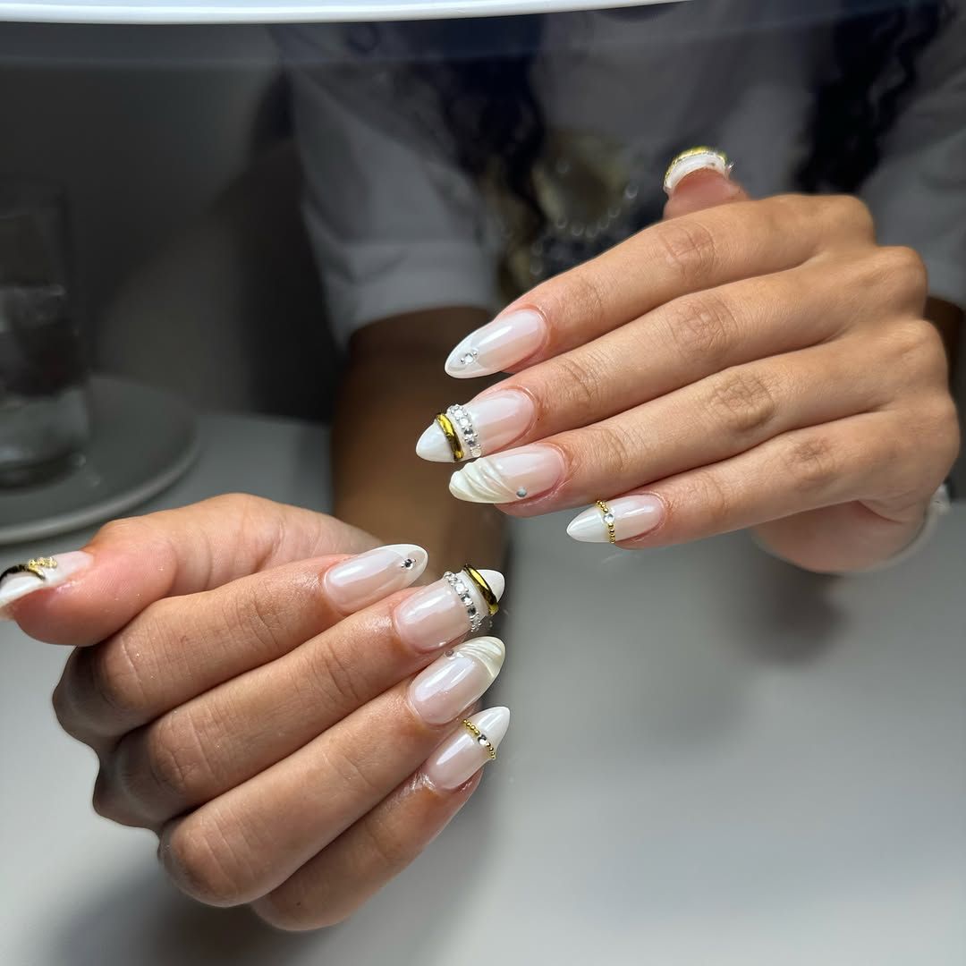 Witte amandelnagels met gouden chrome krullen